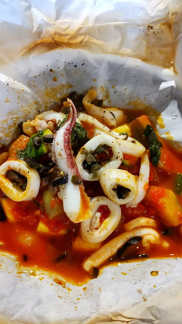 福岡産ヤリイカと季節野菜のトマト煮込みの紙包み焼き（炭焼イタリアン ViNO）